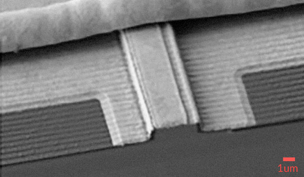 
        Scanning electron microscope (SEM) image of MDL’s laterally coupled (LC) distributed feedback (DFB) laser. Lateral gratings along the ridge sidewall are written with electron-beam lithography, and the grating pitch selects the single-frequency emission wavelength.
    